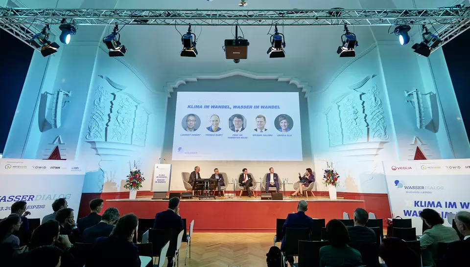 WasserDialog in der Kongresshalle in Leipzig, Zuschauer sitzen in Reihen und folgen einer Podiumsdiskussion
