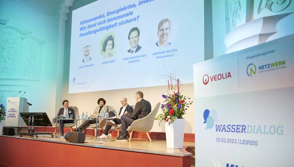 Podiumsdiskussion während des WasserDialogs mit vier Personen sitzend im Podium