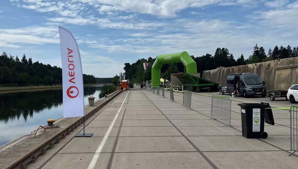 Teil der Laufstrecke an einem Fluss entlang und auf der anderen Seite steht ein Veolia Umleerbehälter