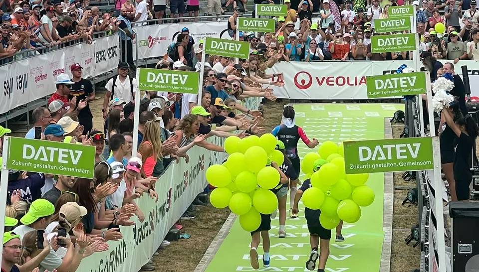 Läufer läuft über die Ziellinie des Triathlons