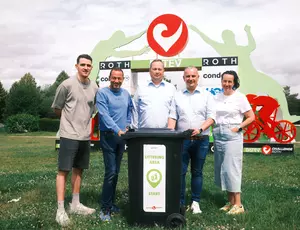 Eine Gruppe mit 5 Personen stehen hinter einem Veolia Umleerbehälter