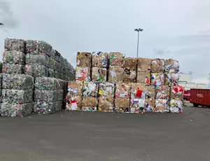 Gepresste Ballen von Folie und Kartonage, rechts daneben ein Veolia Container
