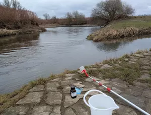 Ein Probenbecher am Ufer der Neisse