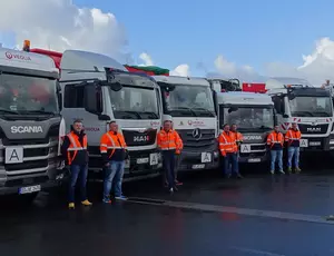 Eine Reihe von LKWs mit ihren Fahrern davor