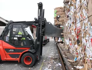 Ein Gabelstapler stapelt Papierballen