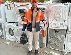 Daniel Marsand vor einem Haufen Elektroschrott
