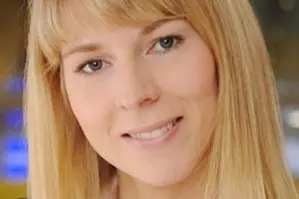 Eine Blonde Frau die in die Kamera lächelt