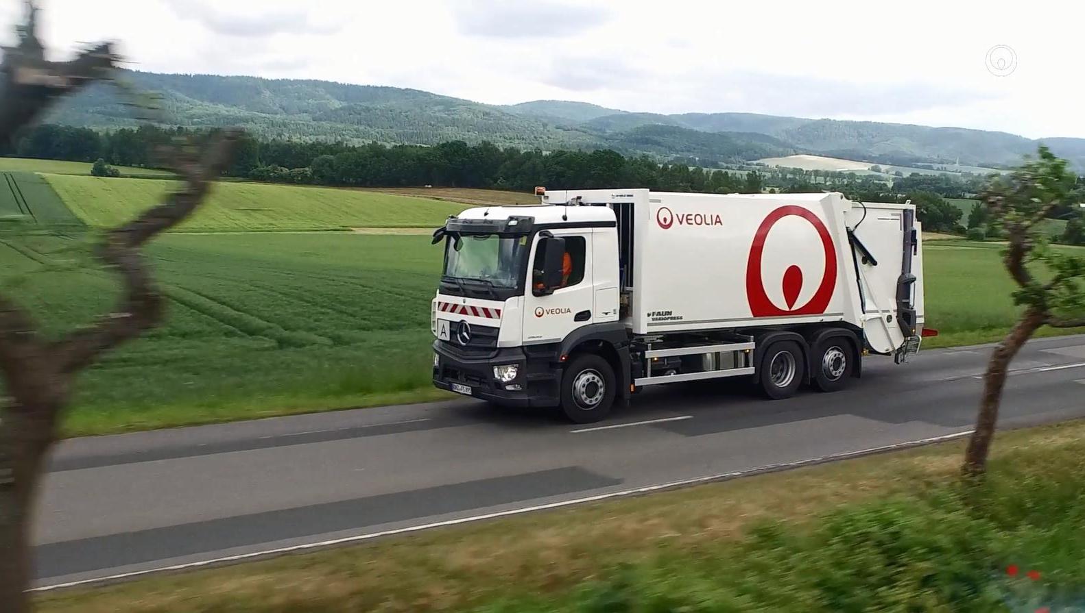 Ein weißes Sammelfahrzeug von Veolia in Deutschland vor landschaftlich treizvoller Kulisse im Harz.