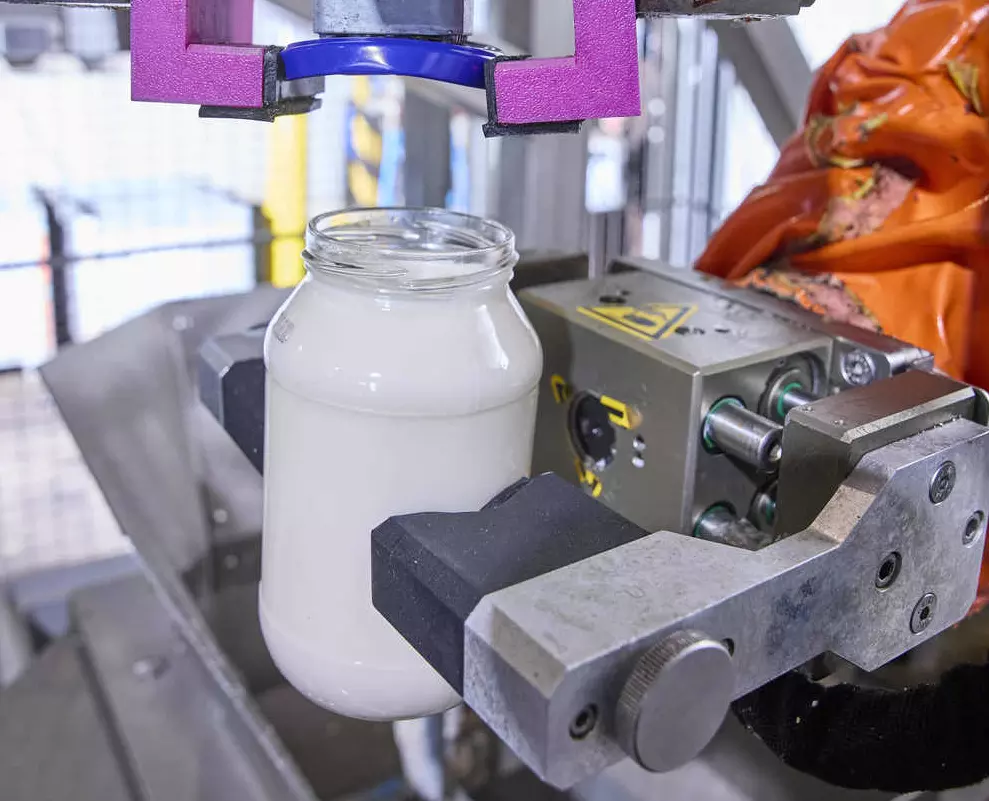 Der Roboter öffnet die Glasbehälter, indem er die Deckel automatisch abschraubt.