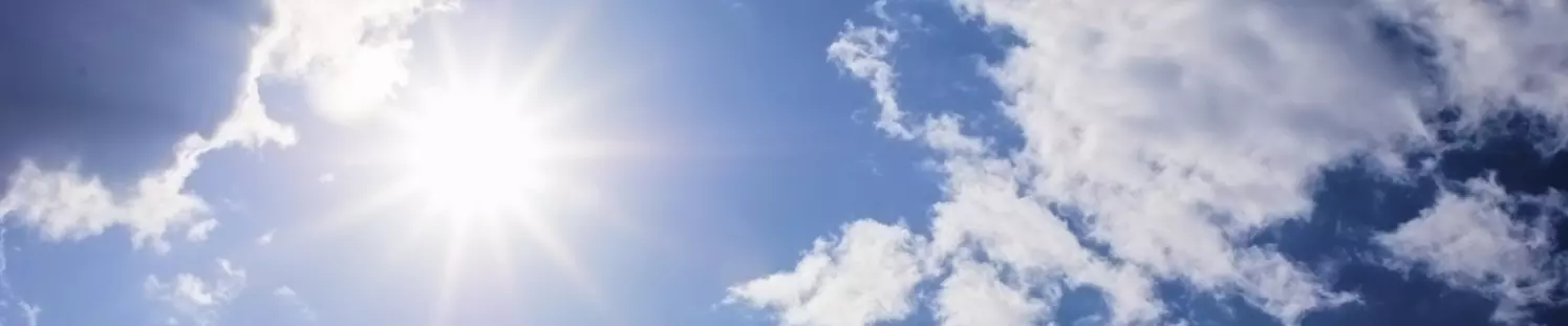 Blauer Himmel mit Sonne und Wolken