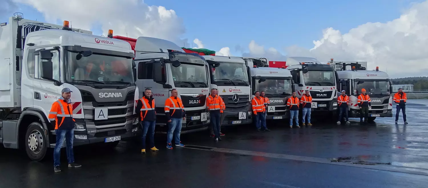 Eine Reihe von LKWs mit ihren Fahrern davor