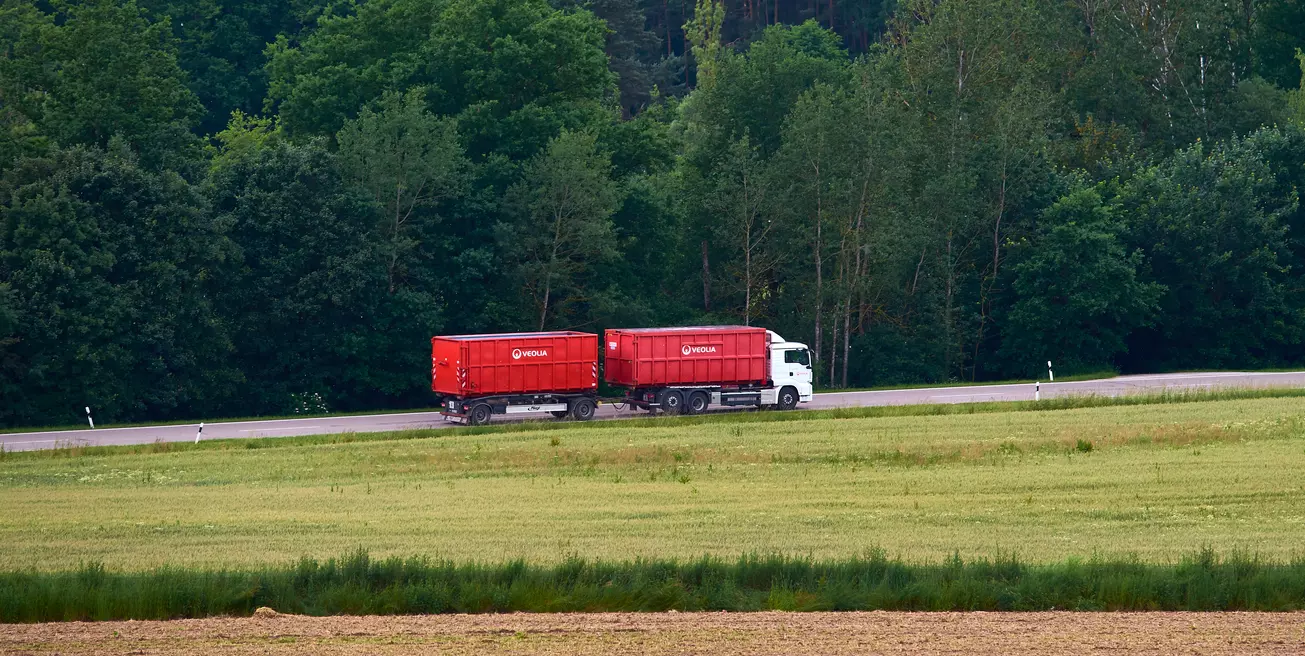 Ein Veolia LKW fährt durch eine grüne Landschaft