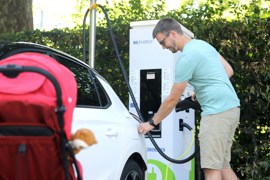 Ein Mann lädt sein E-Auto auf