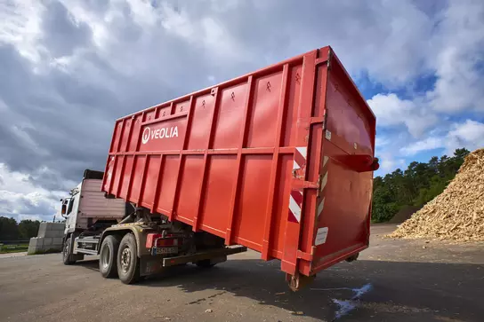 Aufnahme eines Veolia Containers in Rot der abgesetzt wird 