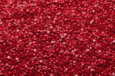 Linsenförmiges, rotes Regranulat aus recyceltem HDPE
