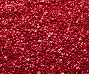 Linsenförmiges, rotes Regranulat aus recyceltem HDPE